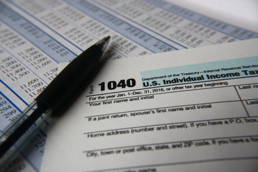 Top portion of 1040 tax form with pen.