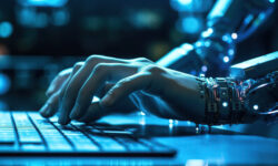 a combination of a human hand and robotic arm are positioned over a keyboard